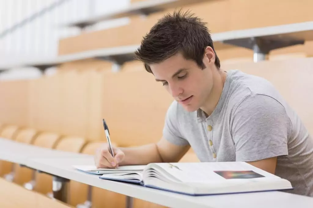 rapaz estudando em sala de aula com livro