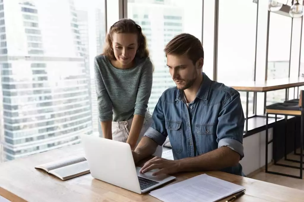 homem e moça analisando computador em escritório