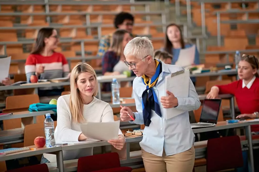 professora e aluna durante aula em auditório