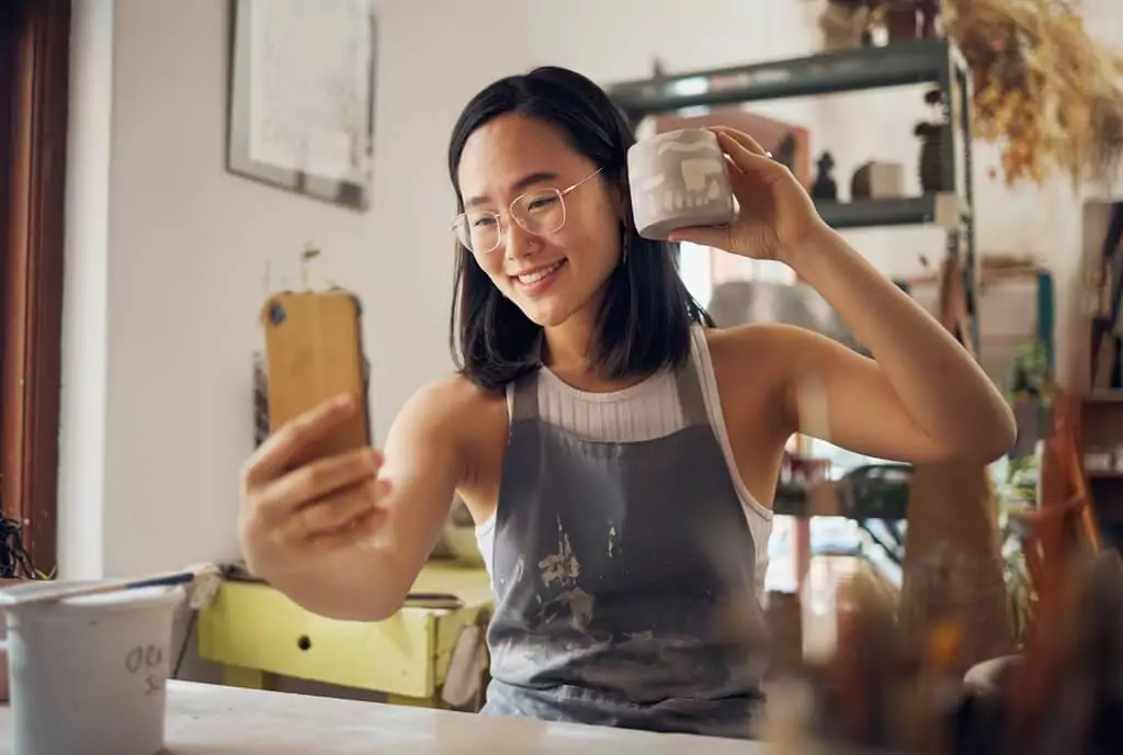 mulher mostrando vaso para foto ou vídeo de celular