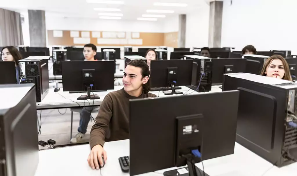 alunos em aula em sala com computadores