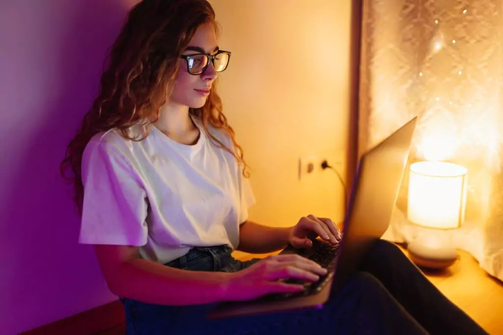 moça estudando com laptop à noite