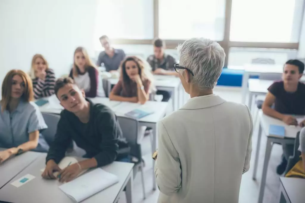 professora em faculdade dando aula a estudantes