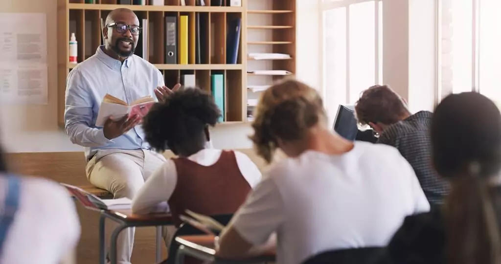 professor dando aula com livro para estudantes