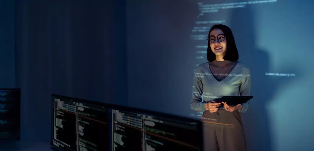 mulher fazendo apresentação em sala com computadores