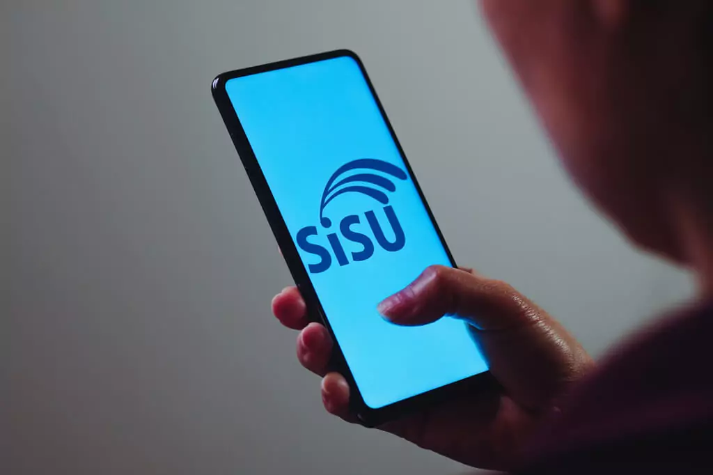 estudante com celular com tela do sisu