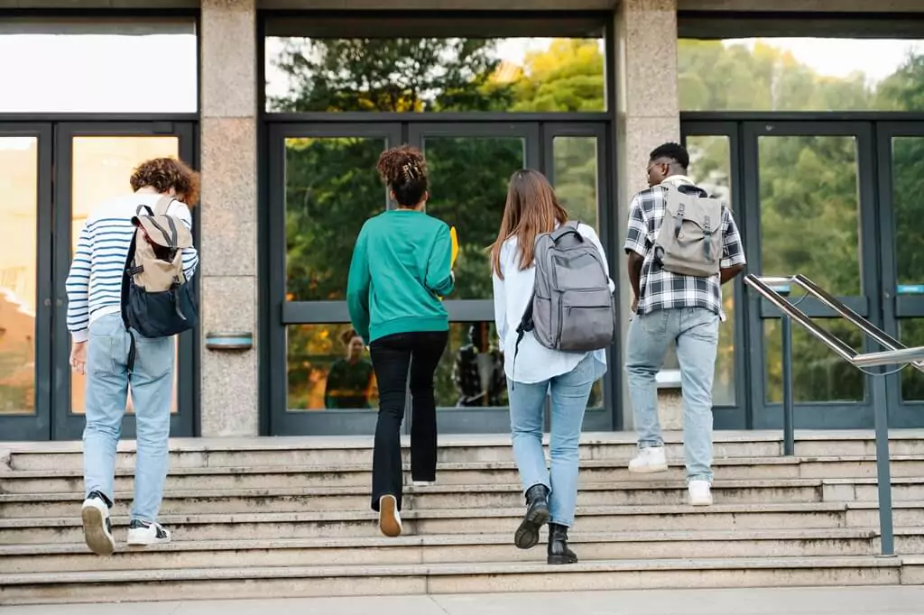 estudantes subindo escada de faculdade