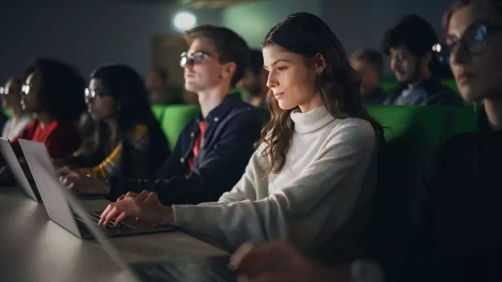 estudantes com computadores em sala de aula