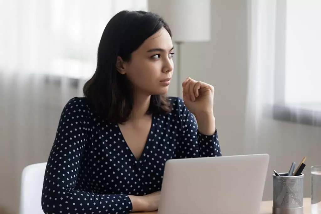 moça pensativa diante de computador