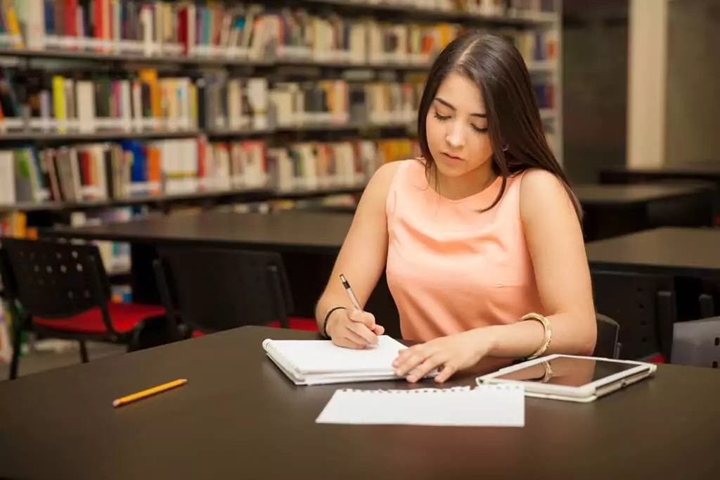 moça estudando em biblioteca