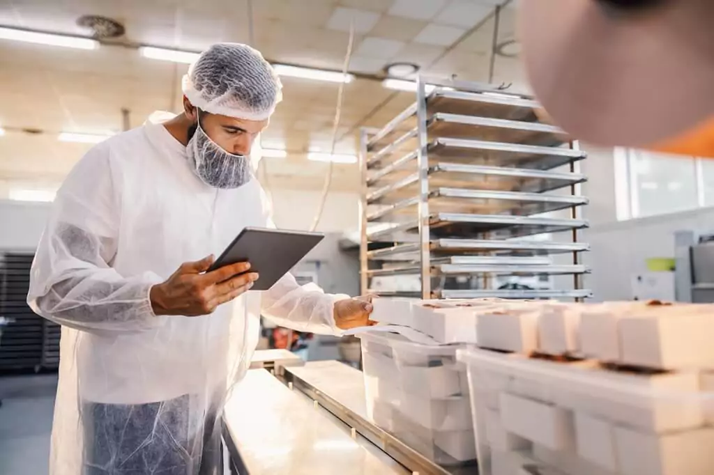 homem em fábrica de comida fazendo supervisão