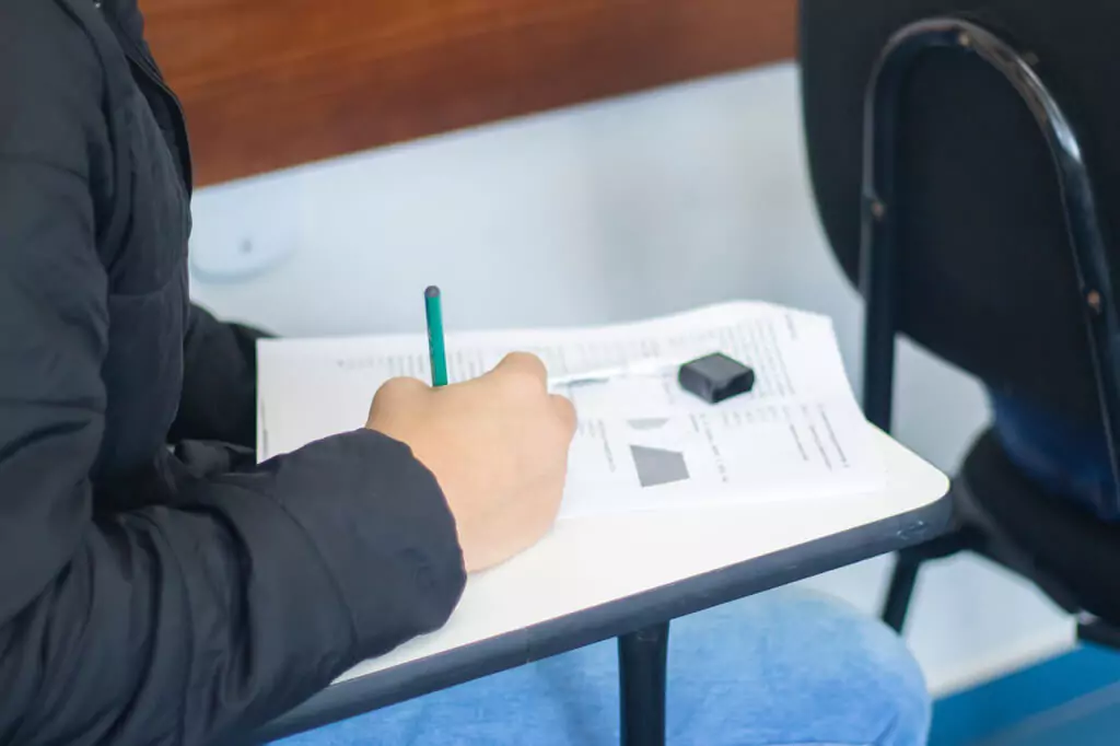 rapaz fazendo prova em sala de aula