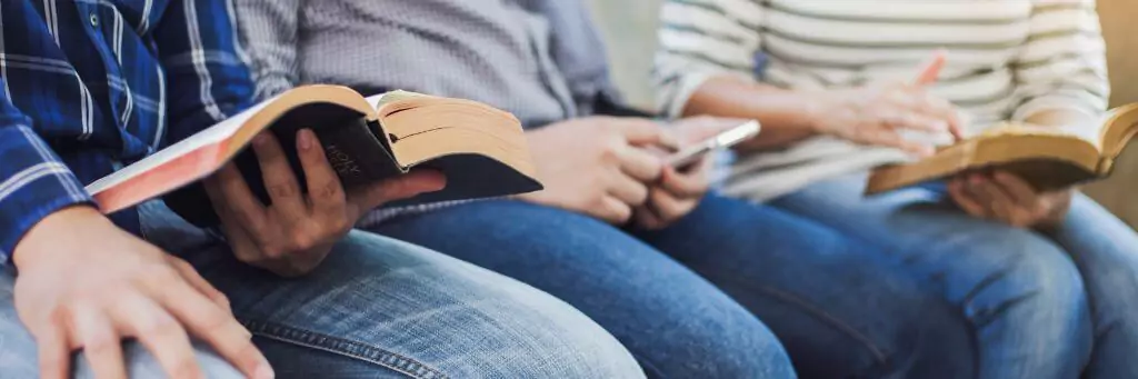 estudantes sentados lendo a Bíblia