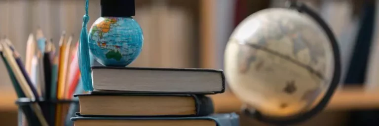 globo terrestre com mini capelo em cima de livros